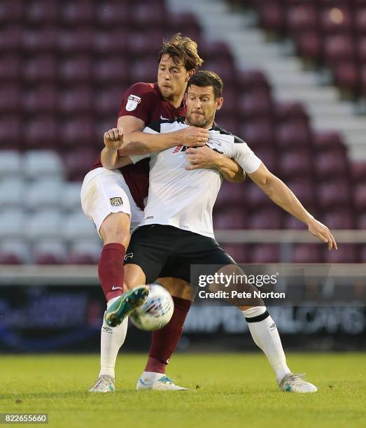 Ash Taylor of Northampton Town contests the ball with David Nugent of Derby County during the Pre-Season Friendly match between Northampton Town and...