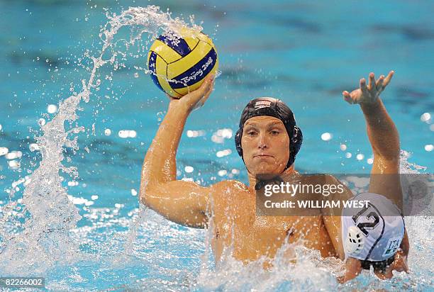 Jesse Smith of the US attempts to throw the ball past Italy's Federico Mistrangelo during their men's preliminary round group B water polo match at...