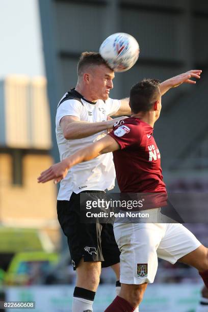 Alex Pearce of Derby County heads the ball under pressure from Marc Richards of Northampton Town during the Pre-Season Friendly match between...