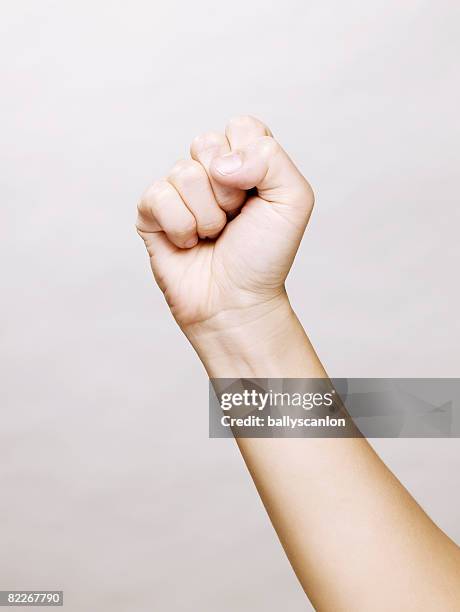 woman's hand making a clinched fist - clenched fist fotografías e imágenes de stock