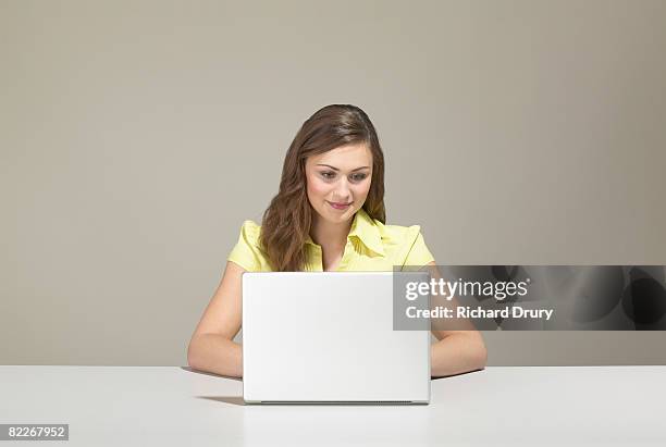 young businesswoman using laptop - laptop coloured background stock pictures, royalty-free photos & images