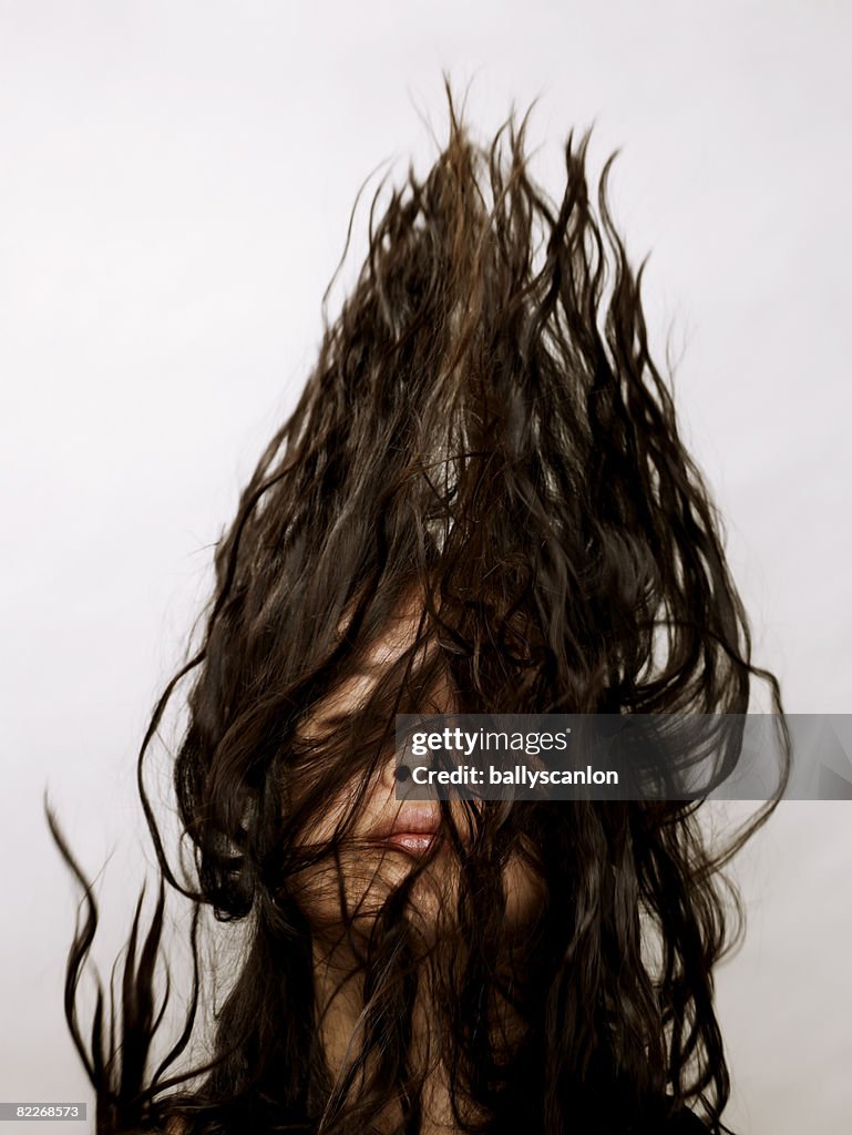 Young asian woman flipping her hair in the air