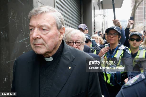 Cardinal George Pell leaves court with a heavy police guard in Melbourne on July 26, 2017 in Melbourne, Australia. Cardinal Pell was charged on...