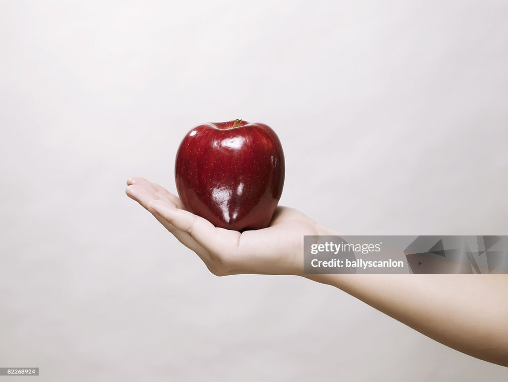 Hand holding a red apple
