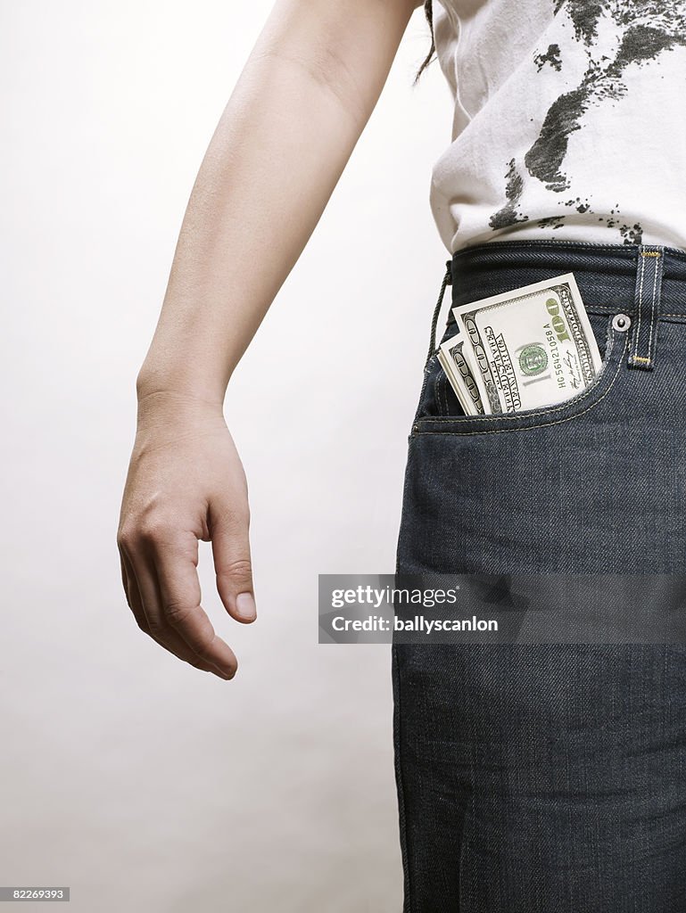 Young asian woman with dollar bills in pocket