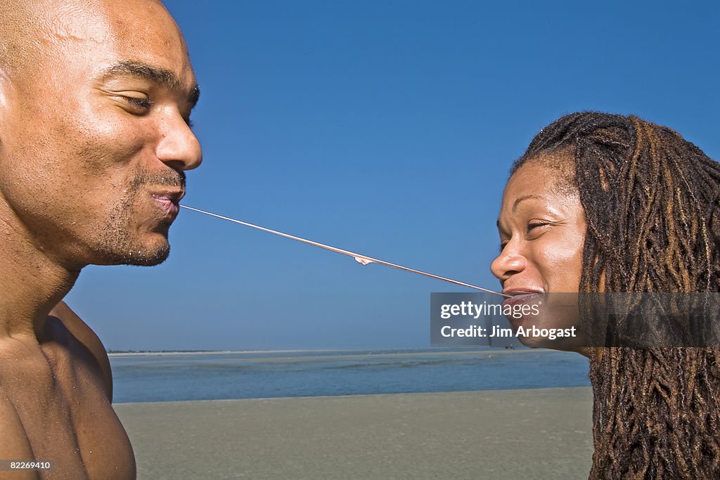 A couple enjoys a piece of gum. 