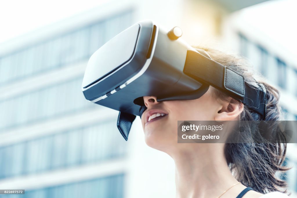 Teenage girl with virtual reality simulator outdoors
