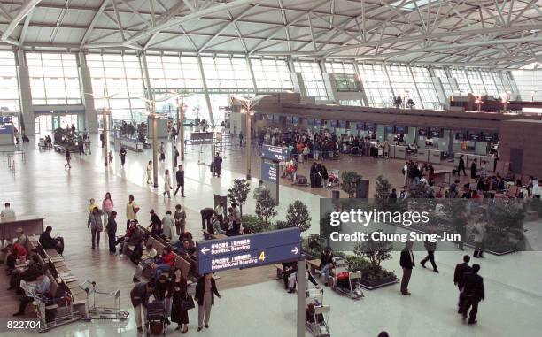 Air travelers wait for their flights April 5, 2001 inside the newly opened Incheon International Airport that lays 32 miles west of Seoul, South...