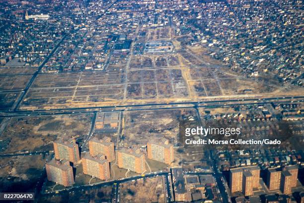 Aerial view facing north of the neighborhoods of Rego Park, Elmhurst, and Corona, Queens, New York City, 1957. The Long Island Expressway runs...