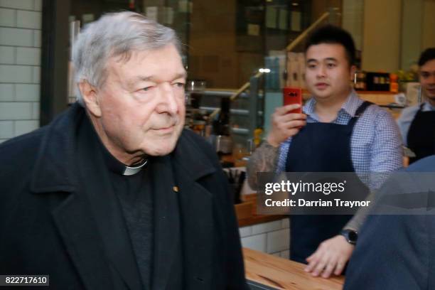 Cardinal George Pell walks with a heavy Police guard from his barristers Robert Richter's office to the Melbourne Magistrates' Court on July 26, 2017...