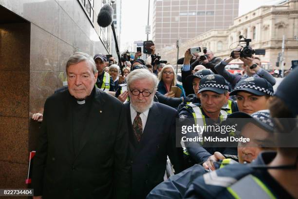 Cardinal George Pell walks with a heavy Police guard from the Melbourne Magistrates' Court on July 26, 2017 in Melbourne, Australia. Cardinal Pell...