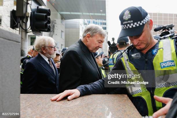 Cardinal George Pell walks with a heavy Police guard from the Melbourne Magistrates' Court on July 26, 2017 in Melbourne, Australia. Cardinal Pell...