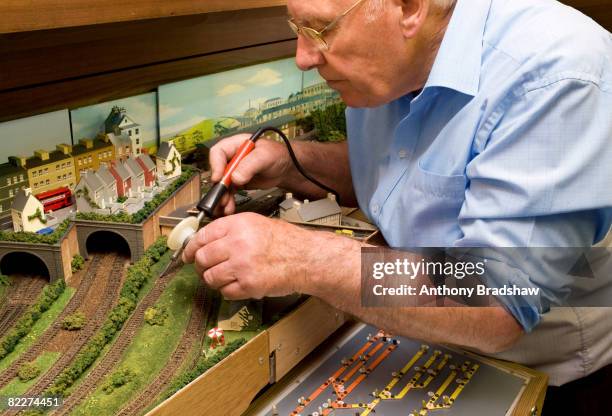 senior builds model railway - speelgoedtrein stockfoto's en -beelden