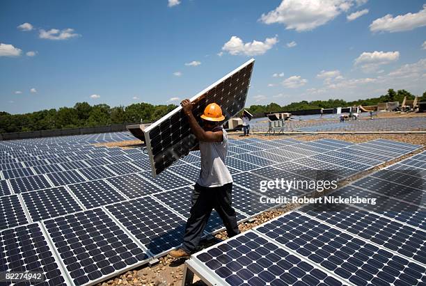 Employees of SunEdison install photovoltaic solar panels on the roof of a Kohl's Department Store on July 15, 2008 in Hillsborough, New Jersey....
