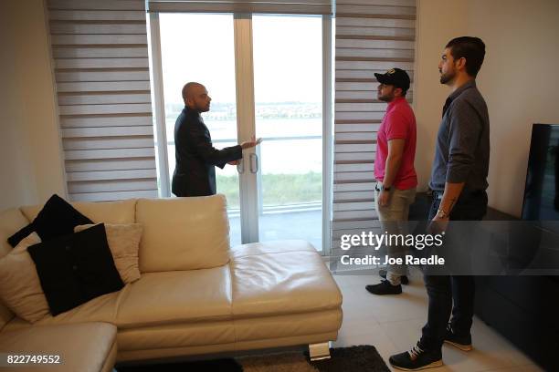 Dario Mucci, Broker Associate RE/MAX Advance Realty, shows a condo at the Midtown Condo building to Carlos Gucciardo and Pascual Simonelli both of...