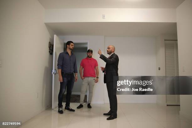 Dario Mucci, Broker Associate RE/MAX Advance Realty, shows a condo at the Midtown Condo building to Carlos Gucciardo and Pascual Simonelli both of...