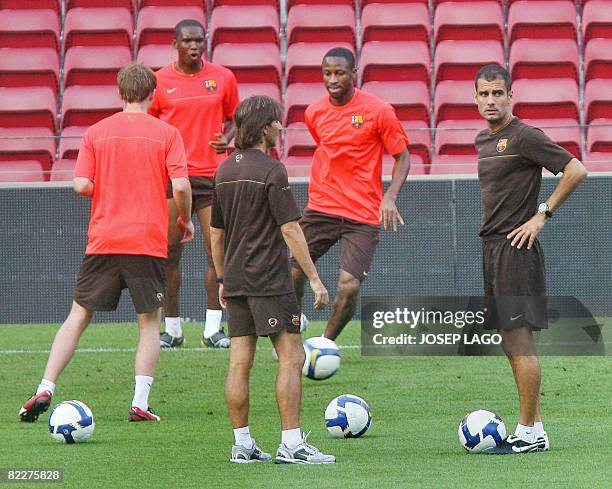 Barcelona's Samuel Eto'o , Seydou Keita and coach Pep Guardiola take part in a training session at the Camp Nou stadium in Barcelona on August 12,...