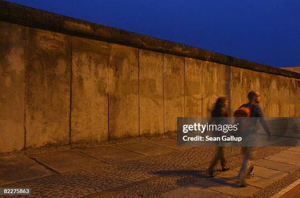 People walk past a still-standing portion of the Berlin Wall in Bernauer Strasse on August 12, 2008 in Berlin, Germany. Berlin will mark the the 47th...