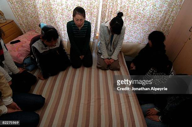 The female portion of the house church are deep in prayer inside one of the two safe houses, on March 23, 2008 in Beijing, China. The group leader,...