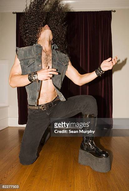 male heavy metal musician playing air guitar - heavy metal stock pictures, royalty-free photos & images