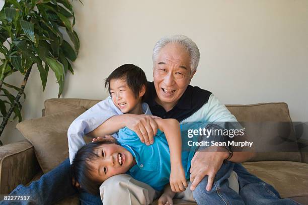 großvater spielen mit zwei grandso - ostasiatischer abstammung stock-fotos und bilder