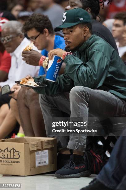 Chance the Rapper drinks a Pepsi while holding pizza while sitting courtside during a BIG3 basketball league game on July 23 at the UIC Pavilion, in...