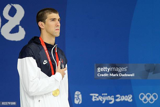 Michael Phelps of the United States poses with the gold medal during the medal ceremony for the Men's 200m Butterfly held at the National Aquatics...