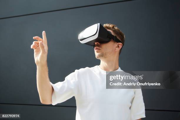 excited man wearing vr glasses outdoors - realidad virtual fotografías e imágenes de stock