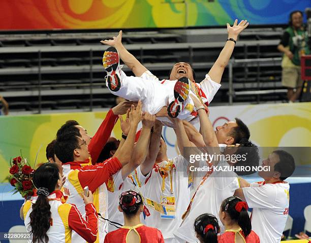 The Chinese team lift Gao Jian, director of the gymnastics center of the State General Administration of Sport , as they celebrate after winning the...