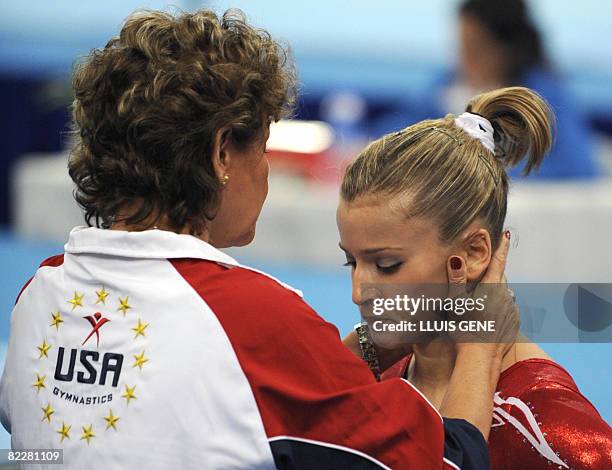 United States' Alicia Sacramone is being conforted during the women's team final of the artistic gymnastics event of the Beijing 2008 Olympic Games...