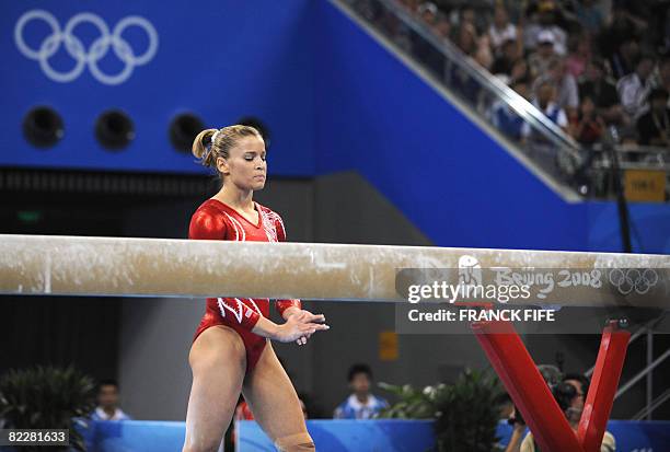 United States' Alicia Sacramone goes back on the beam after falling while competing beam during the women's team final of the artistic gymnastics...