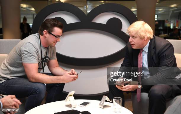 Britain's Foreign Minister Boris Johnson speaks with Iain Griffin, CEO of SeatFrog during a visit to the Tyro Fintech technology Hub on July 26, 2017...