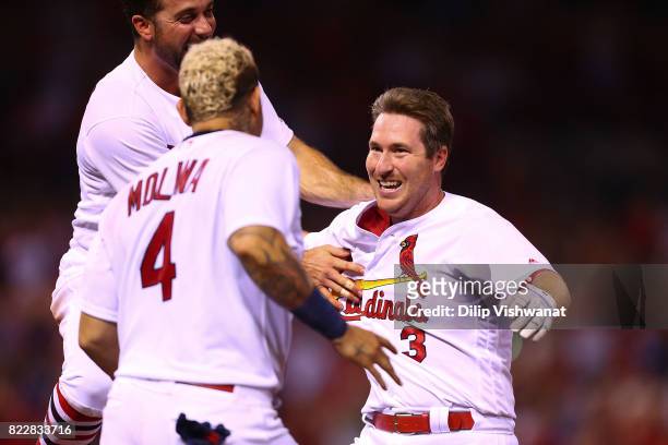 Jedd Gyorko of the St. Louis Cardinals is mobbed by his teammates after batting in the game-winning RBI against the Colorado Rockies in the ninth...