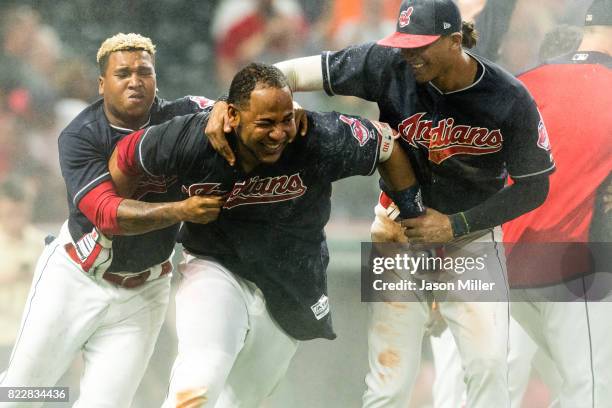 Jose Ramirez and Erik Gonzalez of the Cleveland Indians celebrate with Edwin Encarnacion after Encarnacion hit a walk-off grand slam home run to...