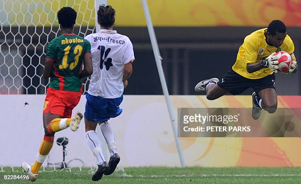 Goalkeeper Amour Tignyemb of Cameroon catches the ball beside of his teammate Gustave Bebbe and Robert Acquafresca of Italy during their 2008 Beijing...