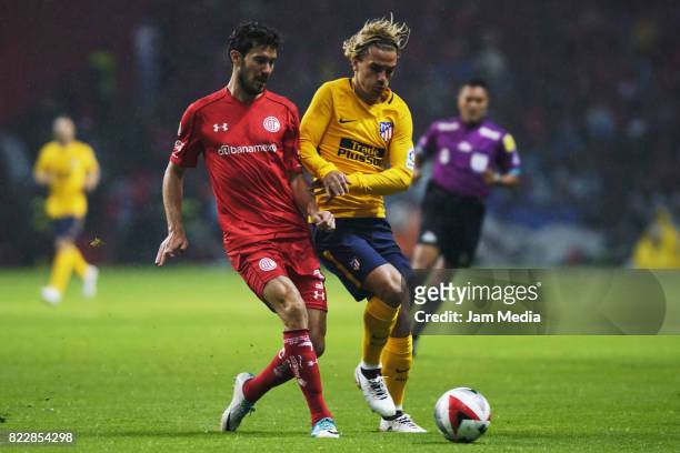 Santiago Garcia of Toluca and Antoine Griezmann of Atletico de Madrid fight for the ball during a friendly match between Toluca and Atletico de...