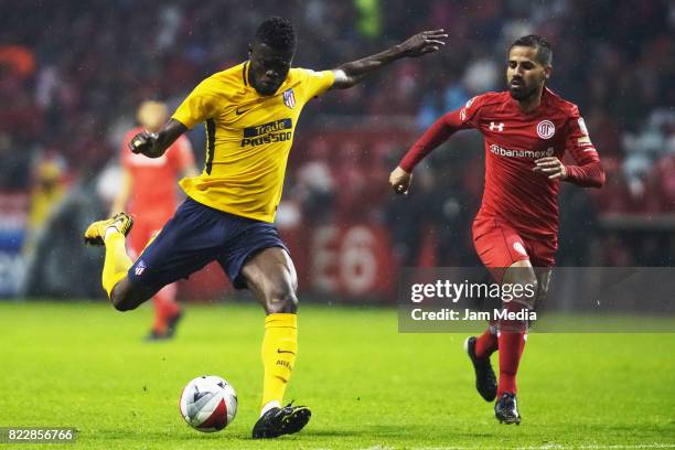 Thomas Teye Partey of Atletico de Madrid shoots the ball as Rodrigo Lopez of Toluca defends during a friendly match between Toluca and Atletico de...