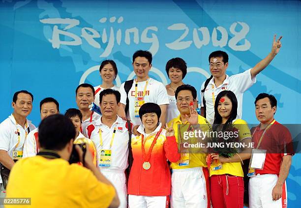 Gold medalist Liu Chunhong of China poses with her team after the medal ceremony for the women's 69 kg weightlifting event during the 2008 Beijing...