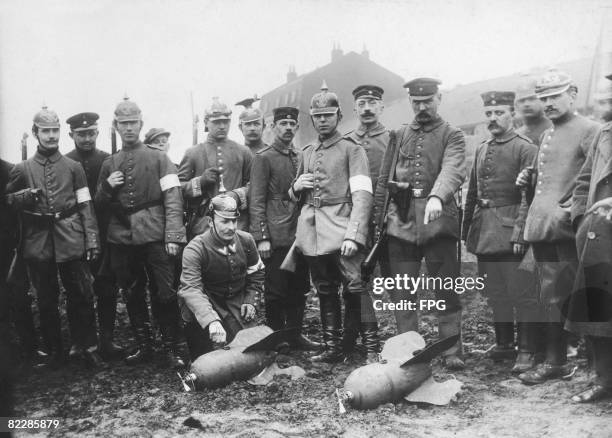 German soldiers standing next to two bombs from an English aircraft after the Battle of Ypres, circa 1915.