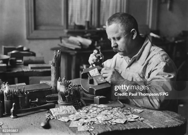 Craftsman stamps the date onto a pile of Iron Cross medals, 1914.