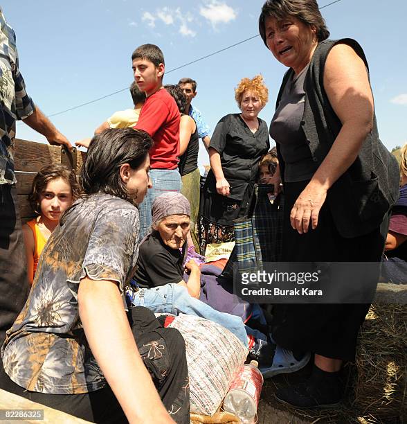 People get on the back of a truck as they flee from the town of Gori, on August 13 in Georgia. According to eye witness reports villages in Georgia...