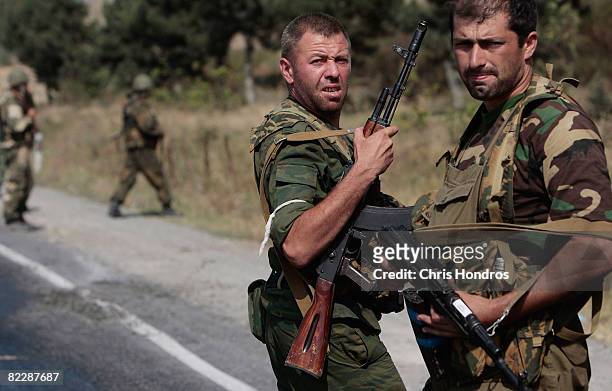 Russia-allied paramilitary soldiers dismount from a Russian miltary convoy August 13, 2008 that moved past the village of Gori, Georgia. A Russian...
