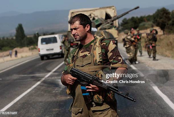 Russia-allied paramilitary soldiers dismount from a Russian miltary convoy August 13, 2008 that moved past the village of Gori, Georgia. A Russian...