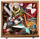 Drawer full of junk, of various household items. On a white background with clipping path