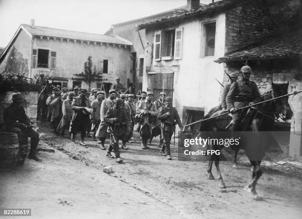 German soldiers lead a group of French prisoners through Vigneulles in north-eastern France during World War I, circa 1916. They were captured in the...