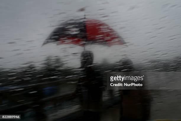 Man holding an umbrella during a heavy rainfall in Dhaka , Bangladesh on Wednesday July, 2017. Moderate to heavy rainfall have been lashing many...