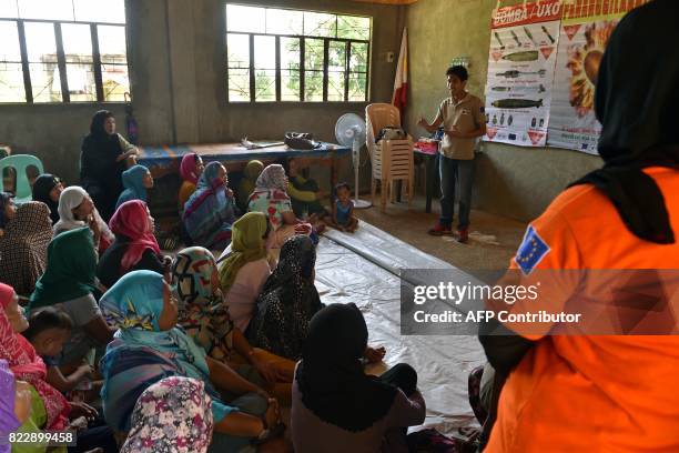 Swiss Foundation for Mine Action volunteer speaks to displaced women on the dangers of bombs and unexploded ordnance at an evacuation centre in...