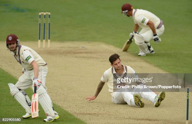 Somerset's James Hildreth and Alviro Petersen take a run as Surrey's Jade Dernbach falls to the ground during the County Championship match between...