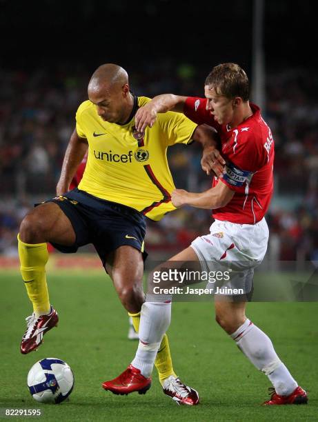 Thierry Henry of Barcelona duels for the ball with Marcin Baszczynski of Wisla Krakow during the UEFA Champions League third Qualifying Round, first...