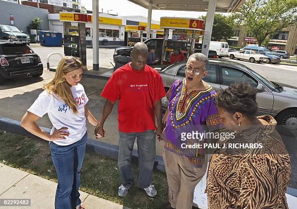 Pray At the Pump founder and leader Rocky Twyman leads Angela Stevens Kenneth Anderson and Jocelyne McClure in prayer thanking God for lower prices...